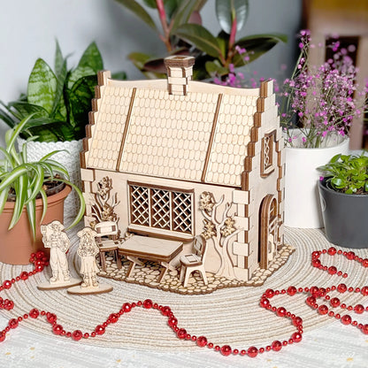 An aesthetic lifestyle shot of a laser cut plywood garden cottage model styled on a table with indoor plants and red beads.