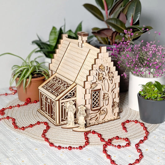 Three-quarter view of a laser cut plywood garden cottage featuring a detailed greenhouse and an engraved tree decoration.