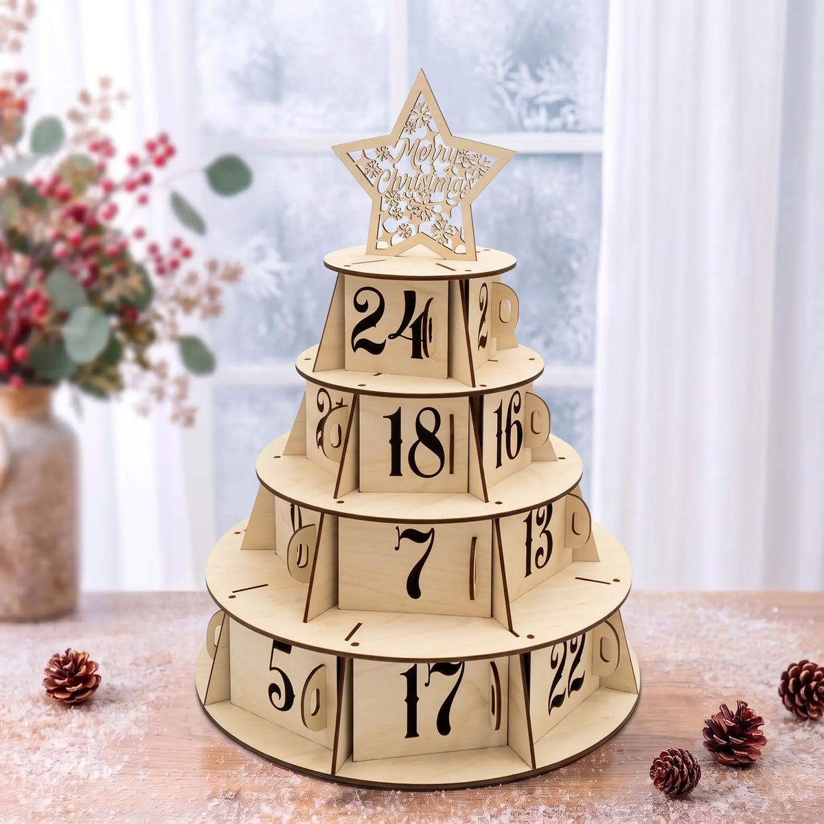 Natural laser cut plywood Christmas tree advent calendar with star topper on snowy wooden table in front of bright window.