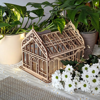 Detailed side angle view of an assembled laser cut plywood micro greenhouse adorned with glowing fairy lights.