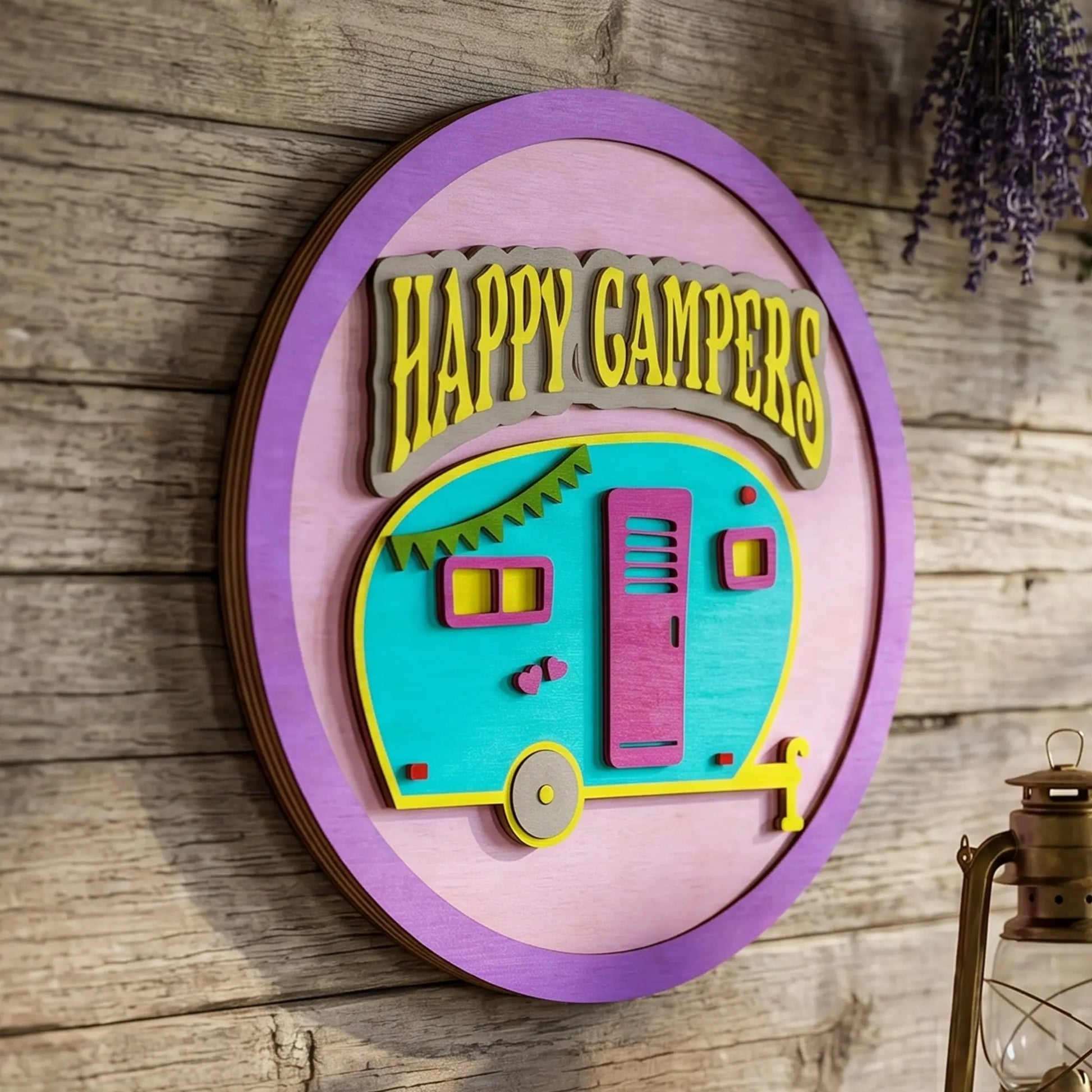 Side view of a layered laser cut plywood Happy Campers sign with a retro trailer on a rustic wall near a vintage lantern