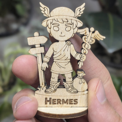 Hand holds a laser cut plywood Hermes for scale. Shows the detailed caduceus, winged hat, and tunic at a miniature scal