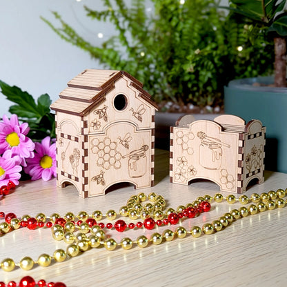 Compact laser cut plywood beehive box next to a small matching box holder styled with gold and red bead garlands.