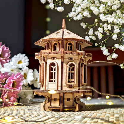 Intricate laser cut plywood garden tower displayed with flowers, highlighting its precise wooden craft and design.