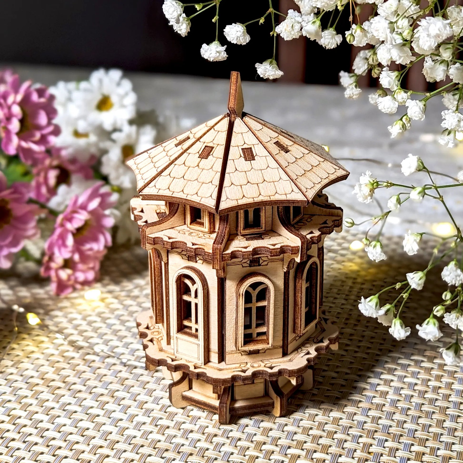 Elegant laser cut plywood tower displayed with floral decor, showing off the precision of the wood assembly.