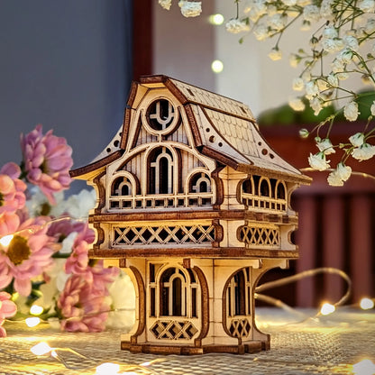 Laser cut plywood gnome house on a table decorated with flowers and fairy lights, showcasing its detailed wooden texture.