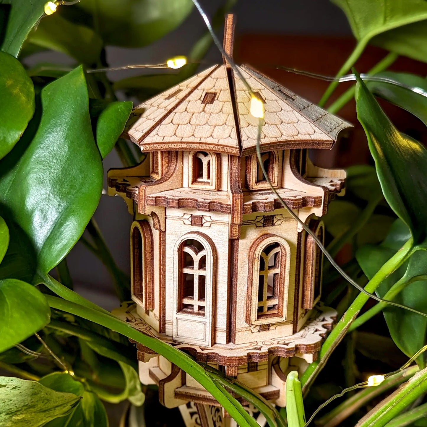 Detailed look at a laser cut plywood tower, emphasizing the craftsmanship of its arched windows and wood texture.