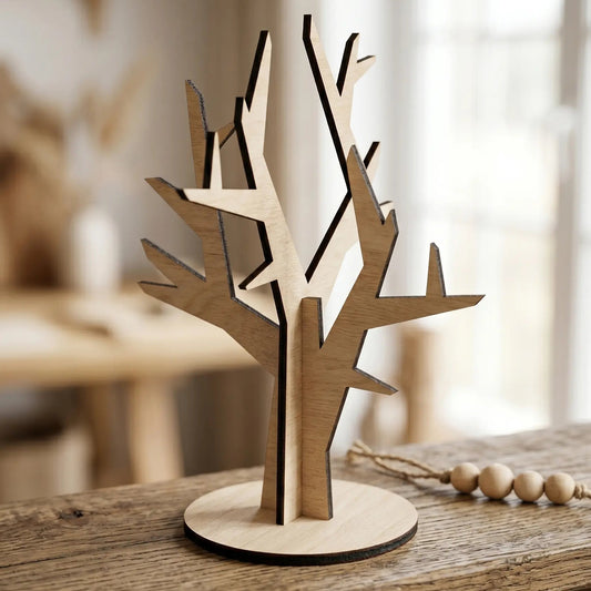 A tree-shaped laser cut plywood jewelry stand on a rustic wooden beam near decorative beads in a bright minimalist interior