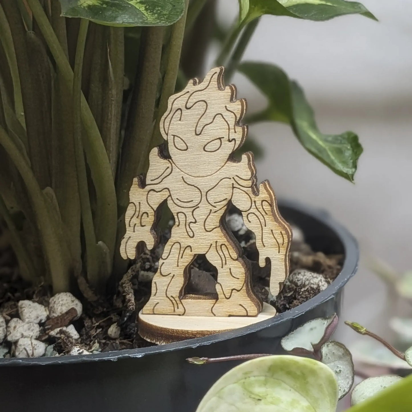 Staged in a plant pot, this laser cut plywood lava elemental figurine features dripping magma details and a flaming head