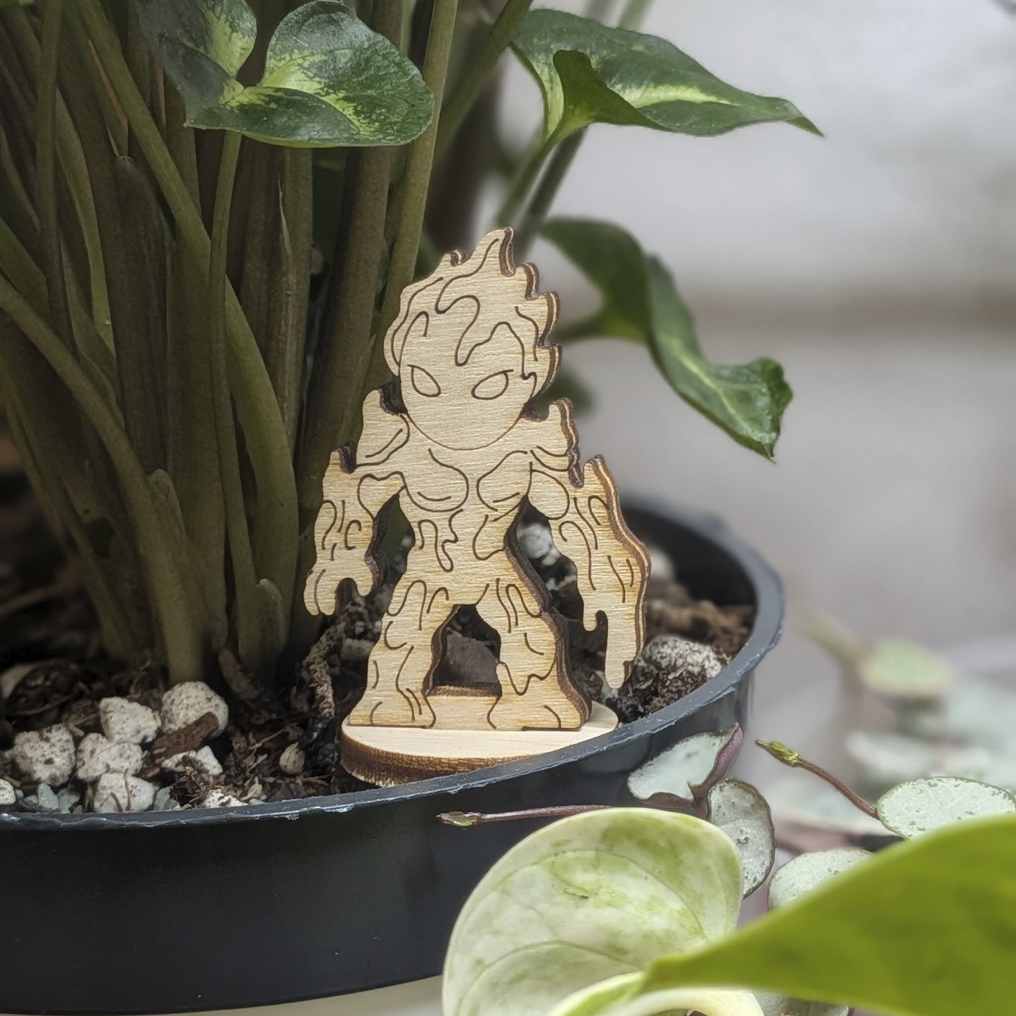 Staged in a plant pot, this laser cut plywood lava elemental figurine features dripping magma details and a flaming head