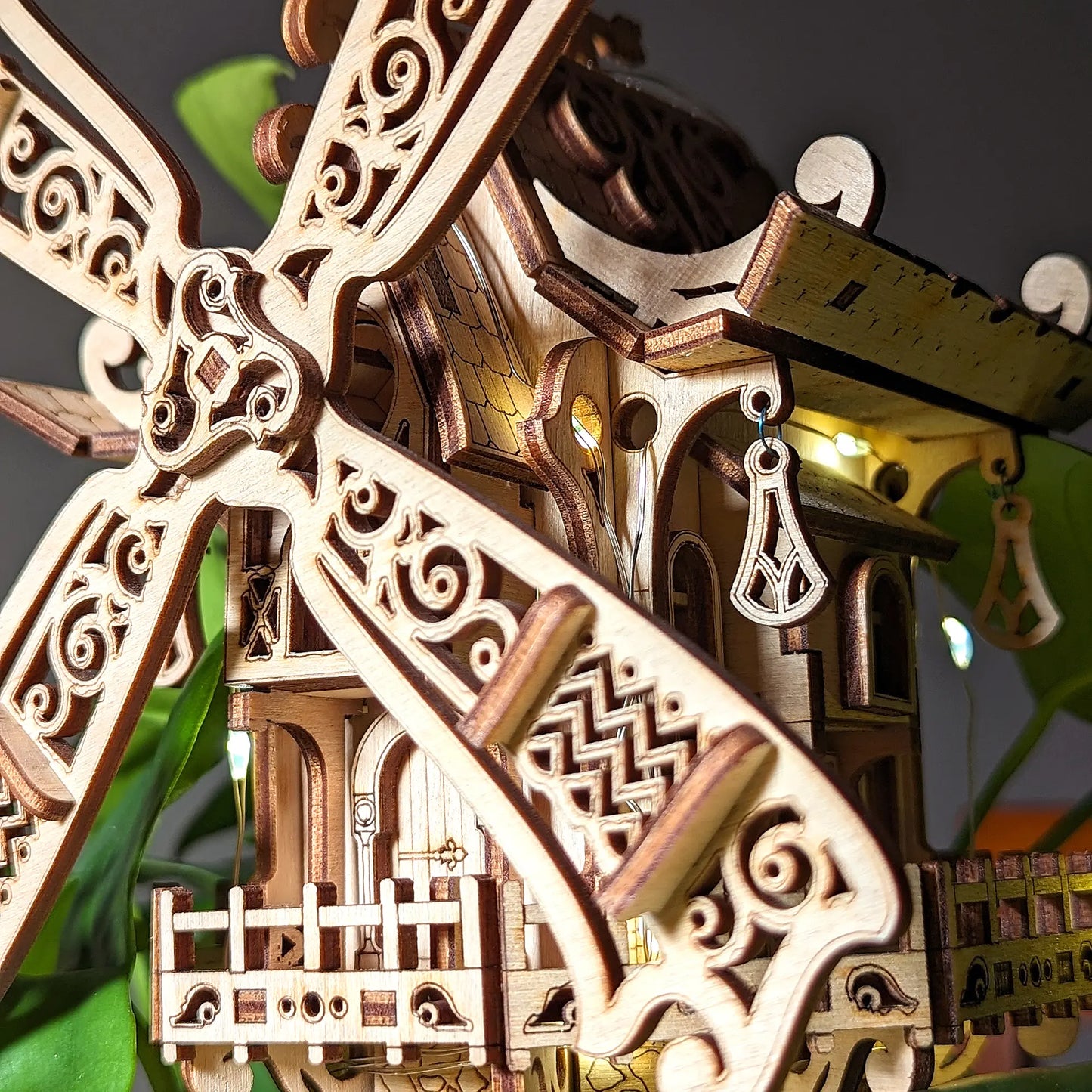 Detailed macro close-up view of a decorative 3D windmill sail featuring delicate charms made from fine laser cut plywood.