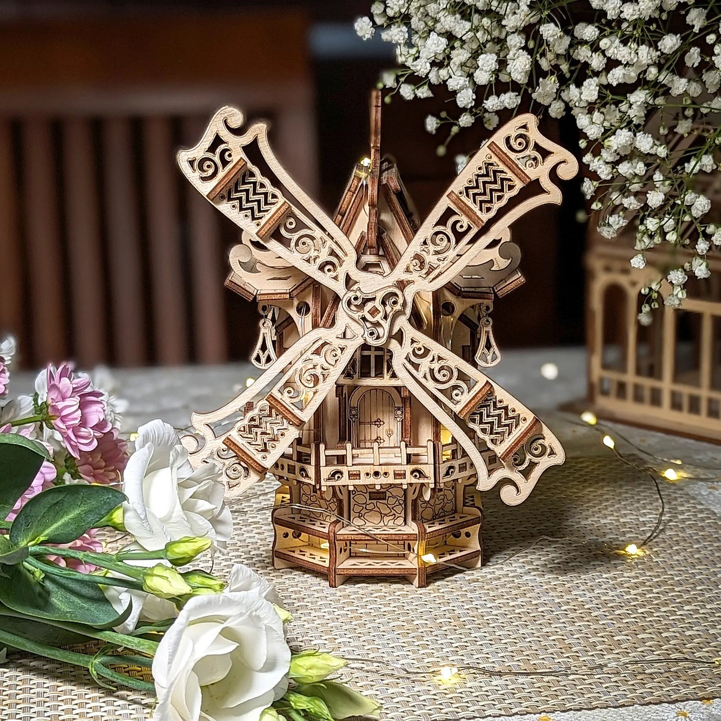 Beautiful perfect front view of a decorative 3D village windmill with filigree sails, crafted from layered laser cut plywood.