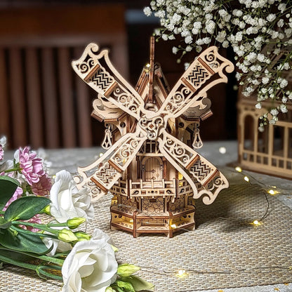 Beautiful perfect front view of a decorative 3D village windmill with filigree sails, crafted from layered laser cut plywood.