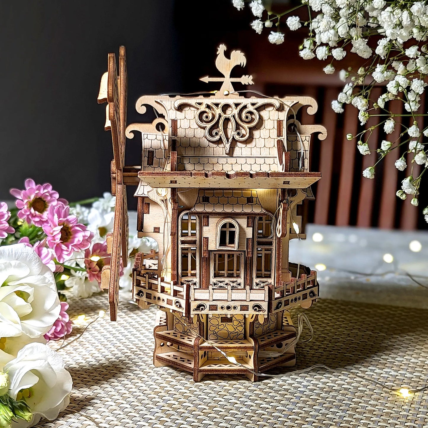 A lovely straight side profile of an intricate 3D holiday windmill with warm lighting, beautifully made of laser cut plywood.
