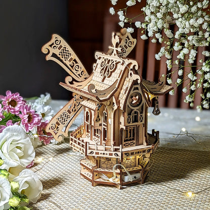 Side angle view of an illuminated decorative 3D windmill with cozy fairy lights and flowers, made from laser cut plywood.