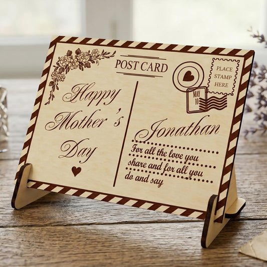 Laser cut plywood Mother's Day postcard on a stand, featuring floral engravings and custom name, on a rustic wood surface
