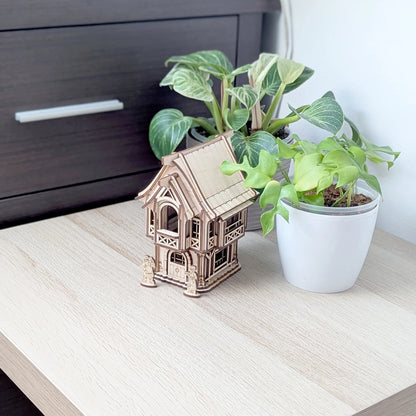 Detailed close-up view of stone brick textures and tiny window frames on a gabled wall of a laser cut plywood model house.