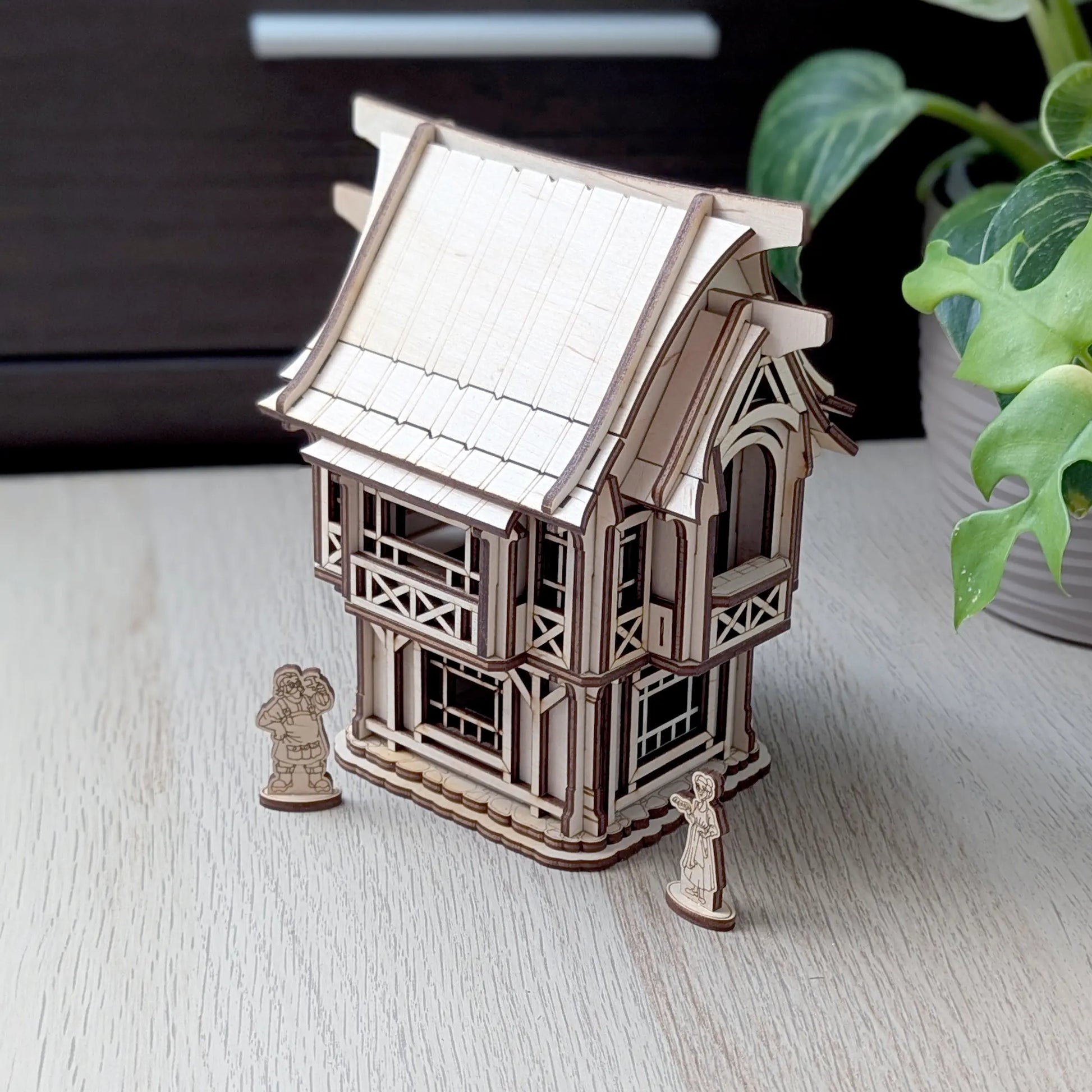 A detailed macro close-up of an intricately engraved blooming tree design on a side wall of a laser cut plywood toy house.
