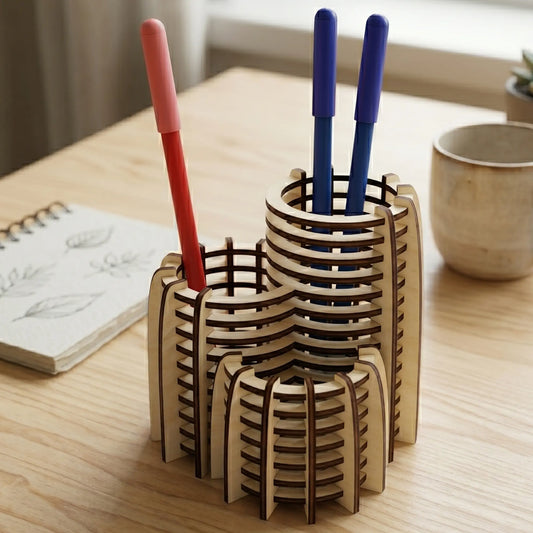 Modern tiered laser cut plywood pen holder on a wooden desk with a notebook and pens in a bright, sunlit Scandinavian room.