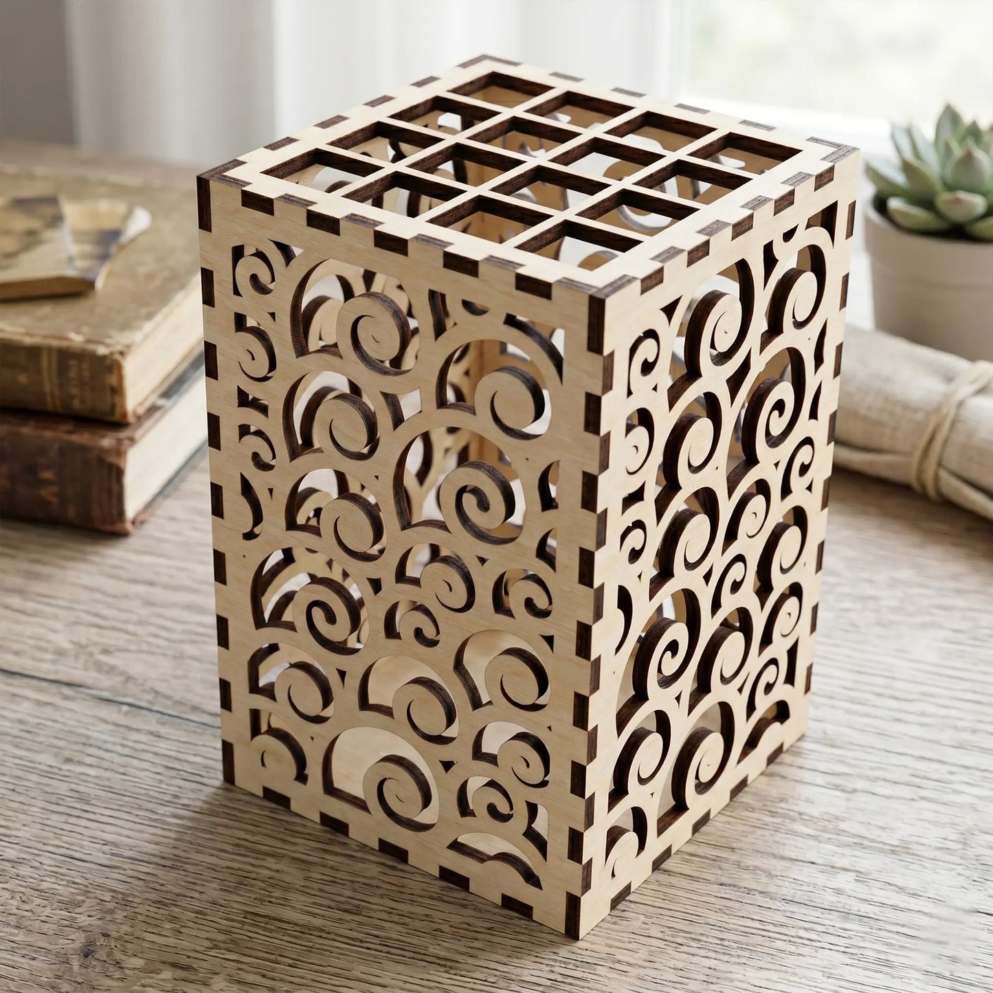 Three laser cut plywood desk organizers with wave, swirl, and scale patterns holding pens and pencils on a linen runner