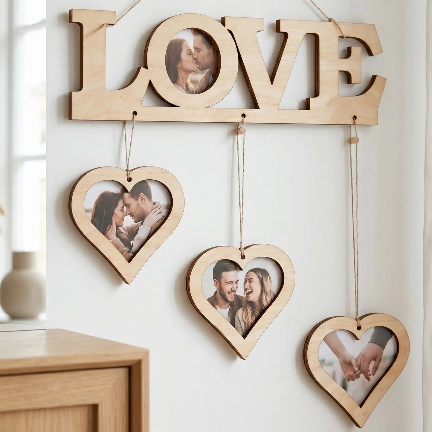 Laser cut plywood LOVE sign with three heart frames hanging on twine, featuring couple's photos on a minimalist white wall