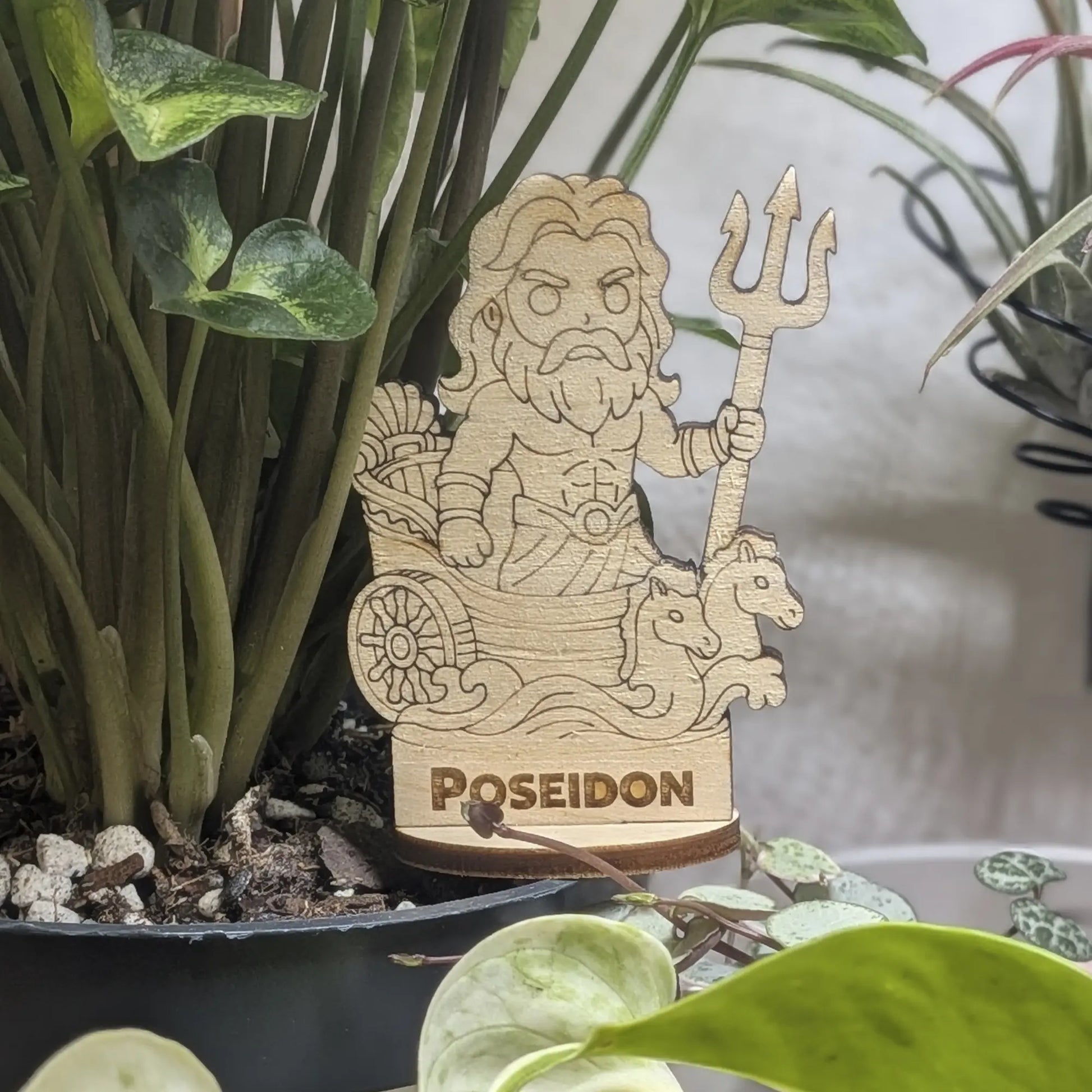 Laser cut plywood Poseidon figurine in a plant pot. Features a trident, crown, and detailed beard on a wood base