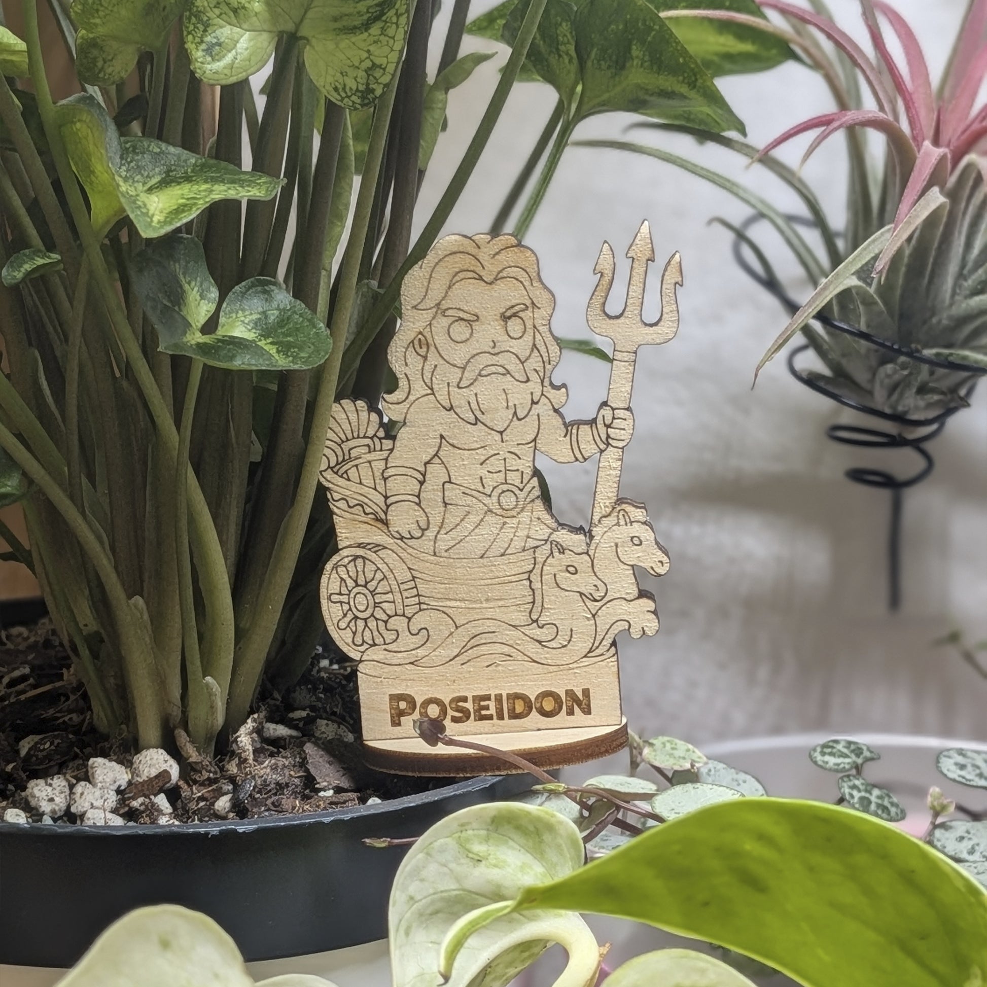 Laser cut plywood Poseidon figurine in a plant pot. Features a trident, crown, and detailed beard on a wood base