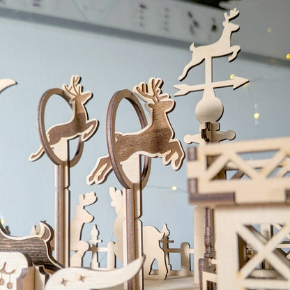 Cut wooden reindeer figures positioned on tall stands and hoops in a festive scene made from a laser cut digital file, with layered silhouettes and holiday accents