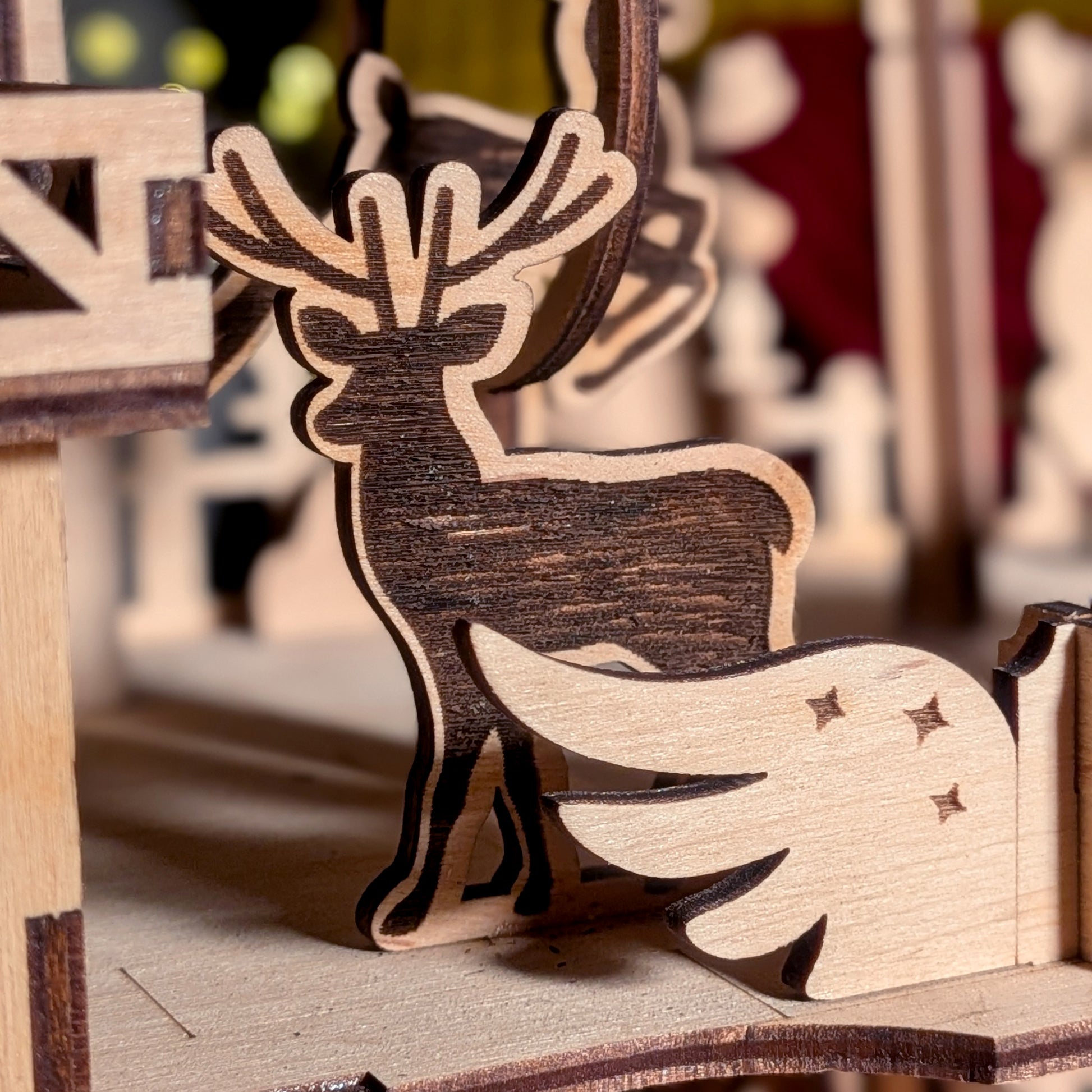 Close-up of a wooden reindeer figure from a laser cut holiday scene, showing engraved texture and layered construction details
