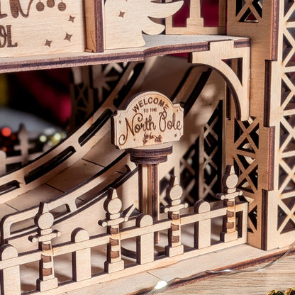 Close-up of the engraved “Welcome to the North Pole” sign in a wooden Christmas display made from a laser cut digital file, with layered fence and curved ramp details.