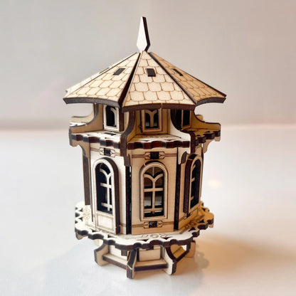 Miniature garden tower made of laser cut plywood. Detailed hexagonal wooden structure with ornate arches and roof tiles.