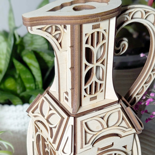 Macro zoom on the intricate carved neck and spout detailing of an assembled decorative laser cut plywood jug fairy house.