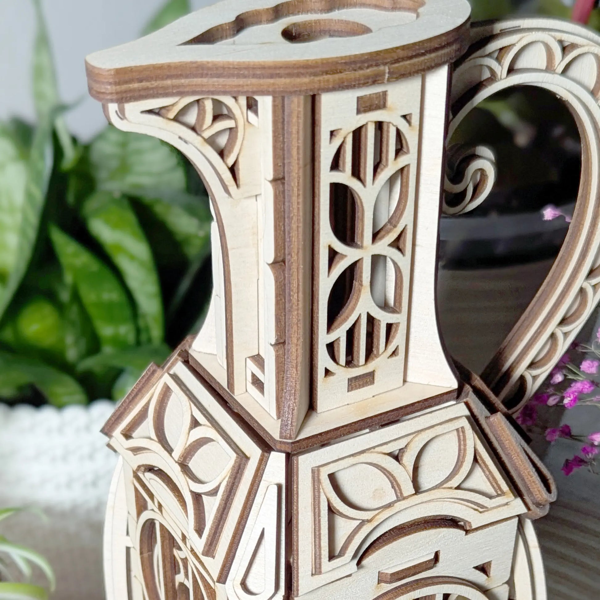 Macro zoom on the intricate carved neck and spout detailing of an assembled decorative laser cut plywood jug fairy house.