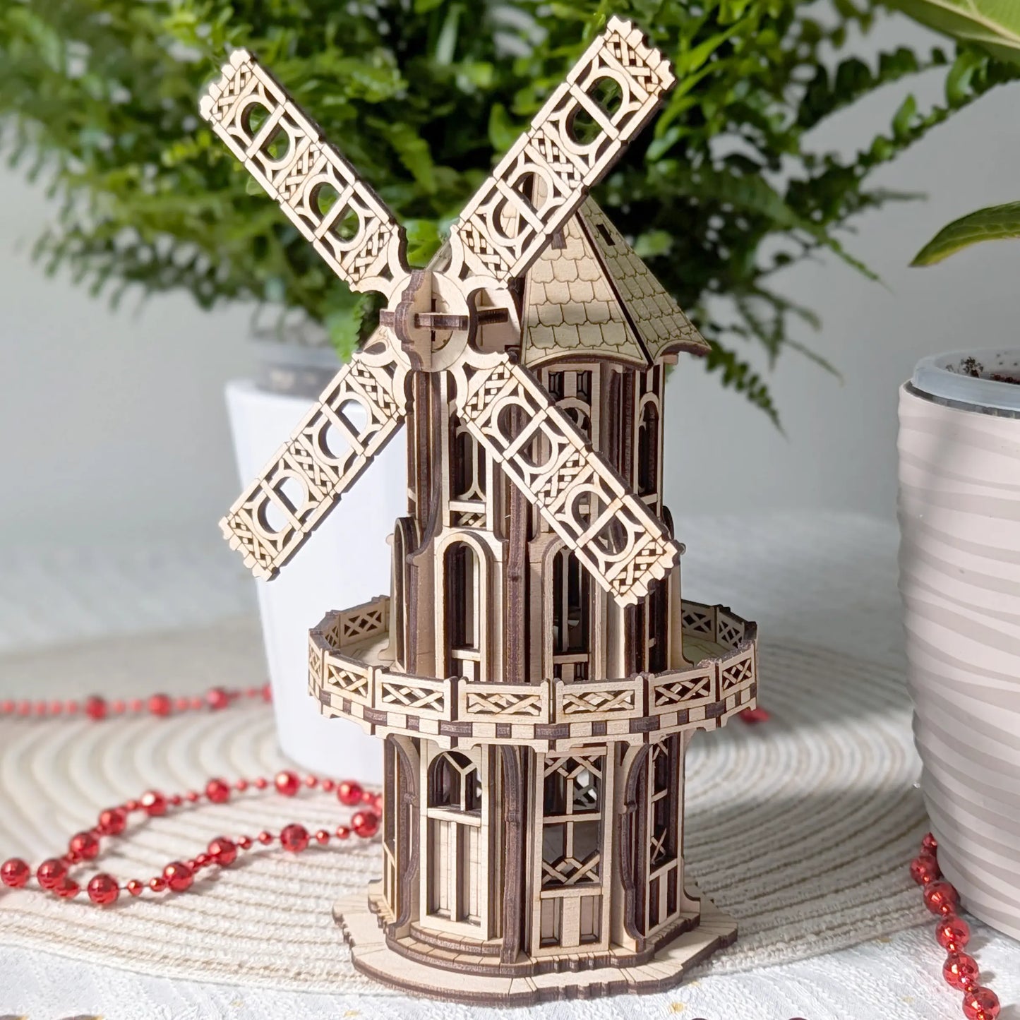 Close-up view of a completed laser cut plywood Victorian windmill detailing its ornate multi-level arched windows.
