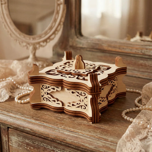 Laser cut plywood closed vintage filigree box on a wooden dresser table with pearl beads and a mirror backdrop.