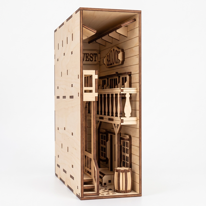 Three-quarter view of a laser-cut birch plywood Wild West saloon book nook featuring a balcony, barrels, and natural wood.