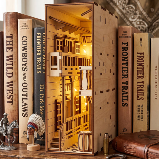 Lit laser-cut birch plywood Wild West saloon book nook on a shelf between western books, with warm internal lights and barrels