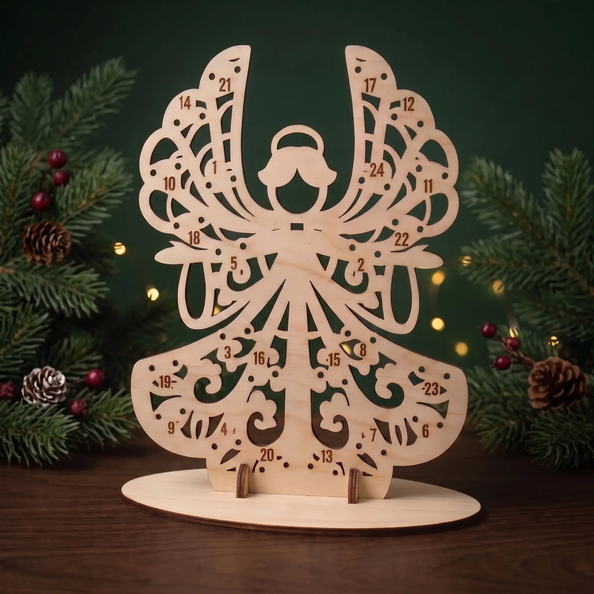 Empty laser cut plywood angel advent calendar stand with numbered lollipop holes framed by pine branches.