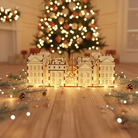 Intricate laser cut wooden Advent Calendar City composed of connected festive houses lit from within, displayed in front of a softly lit Christmas tree with golden bokeh lights.