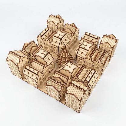 High angle view of laser cut plywood advent calendar city model with tiny houses and central fir tree on white background.