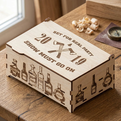 Custom laser cut plywood gift box engraved with 'Set for Real Party' and bottle illustrations on a rustic wooden table