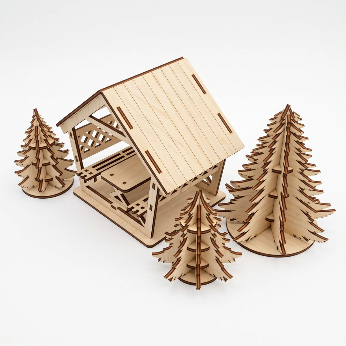 Top angle view of laser cut plywood gazebo kit with slatted roof and three 3D Christmas trees on seamless white background.