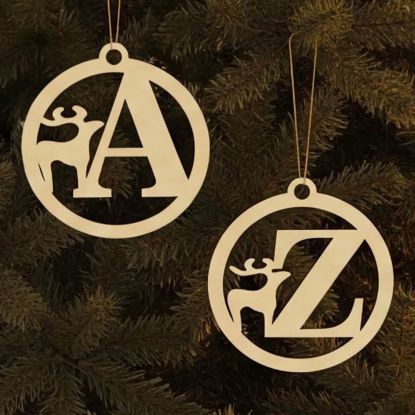 Laser cut wooden Alphabet for Christmas tree featuring round ornaments with large letters and cute reindeer silhouettes, displayed against a warm glowing Christmas tree background.