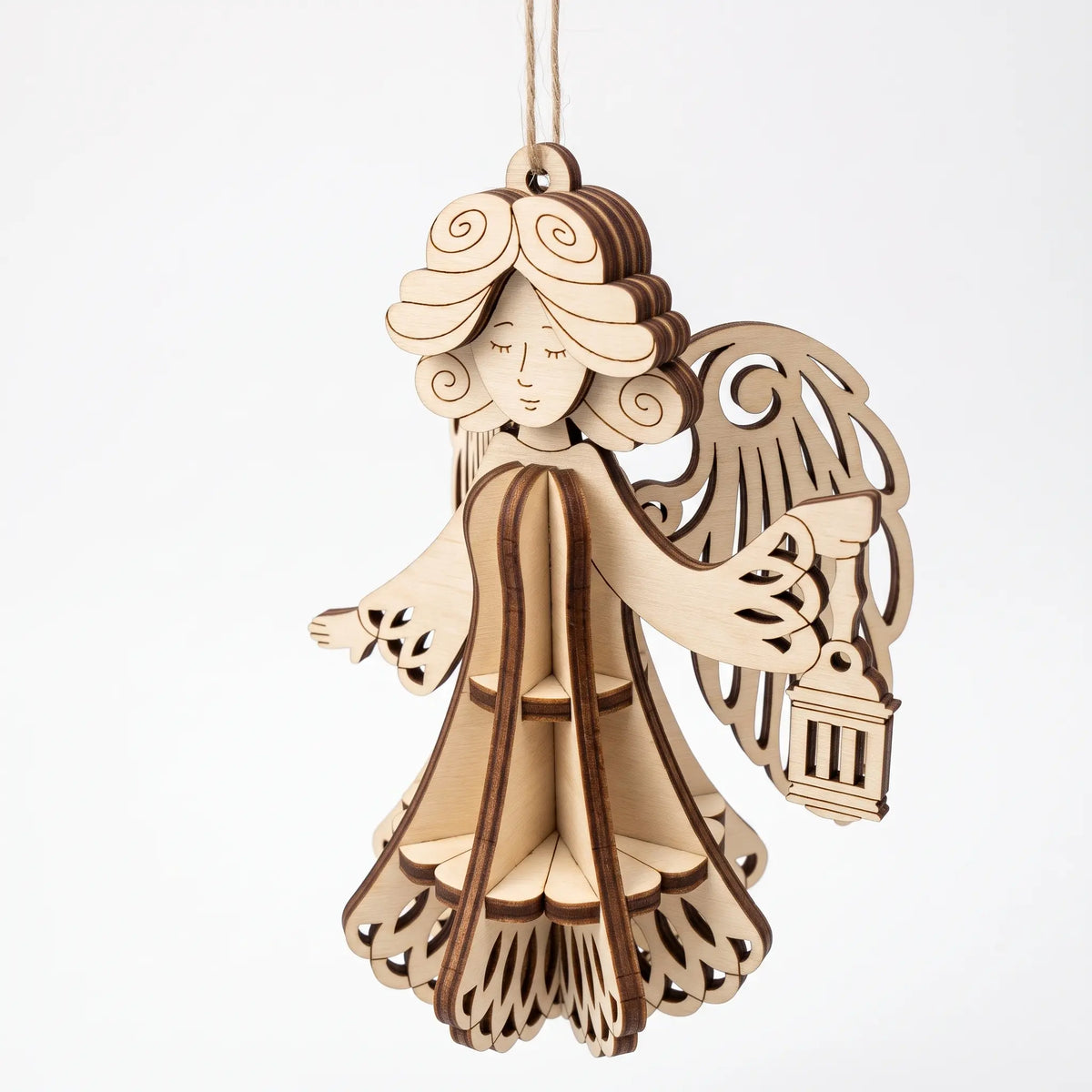 Perspective view of hanging 3D laser cut plywood angel bauble holding lantern with slotted flared gown on white.
