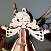 Wooden laser cut angel ornament with outstretched wings on a dark background