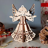 Wooden laser cut angel ornament with intricate design on a decorative surface.