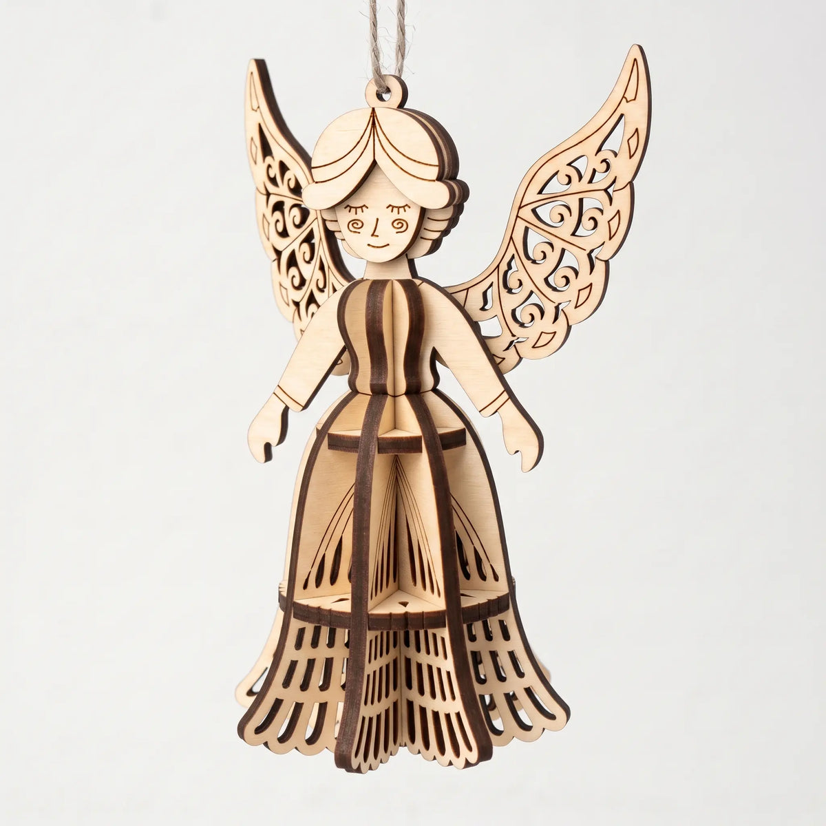 3D laser cut plywood angel figurine ornament with filigree wings and slotted skirt hanging over a plain white background.