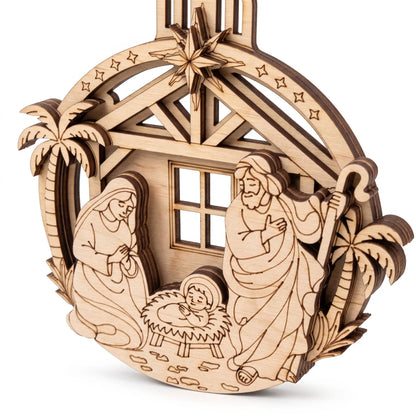 Angled close-up of multilayered laser cut plywood nativity bauble showing clean 3D relief edges on white background