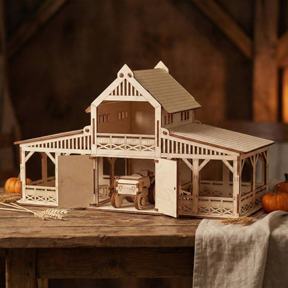 Laser cut plywood toy barn with open stable doors on a wooden table. A small wooden tractor sits inside the central bay. The structure features intricate railings, a peaked roof, and a decorative balcony.