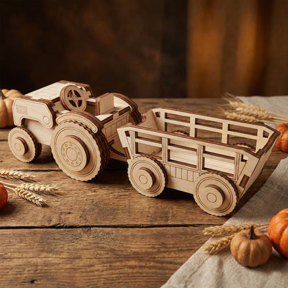 Close-up of a laser cut plywood tractor hitched to a matching four-wheeled trailer on a wooden surface. The wood features dark burnt edges from the laser, showing assembly layers and realistic wheel treads.
